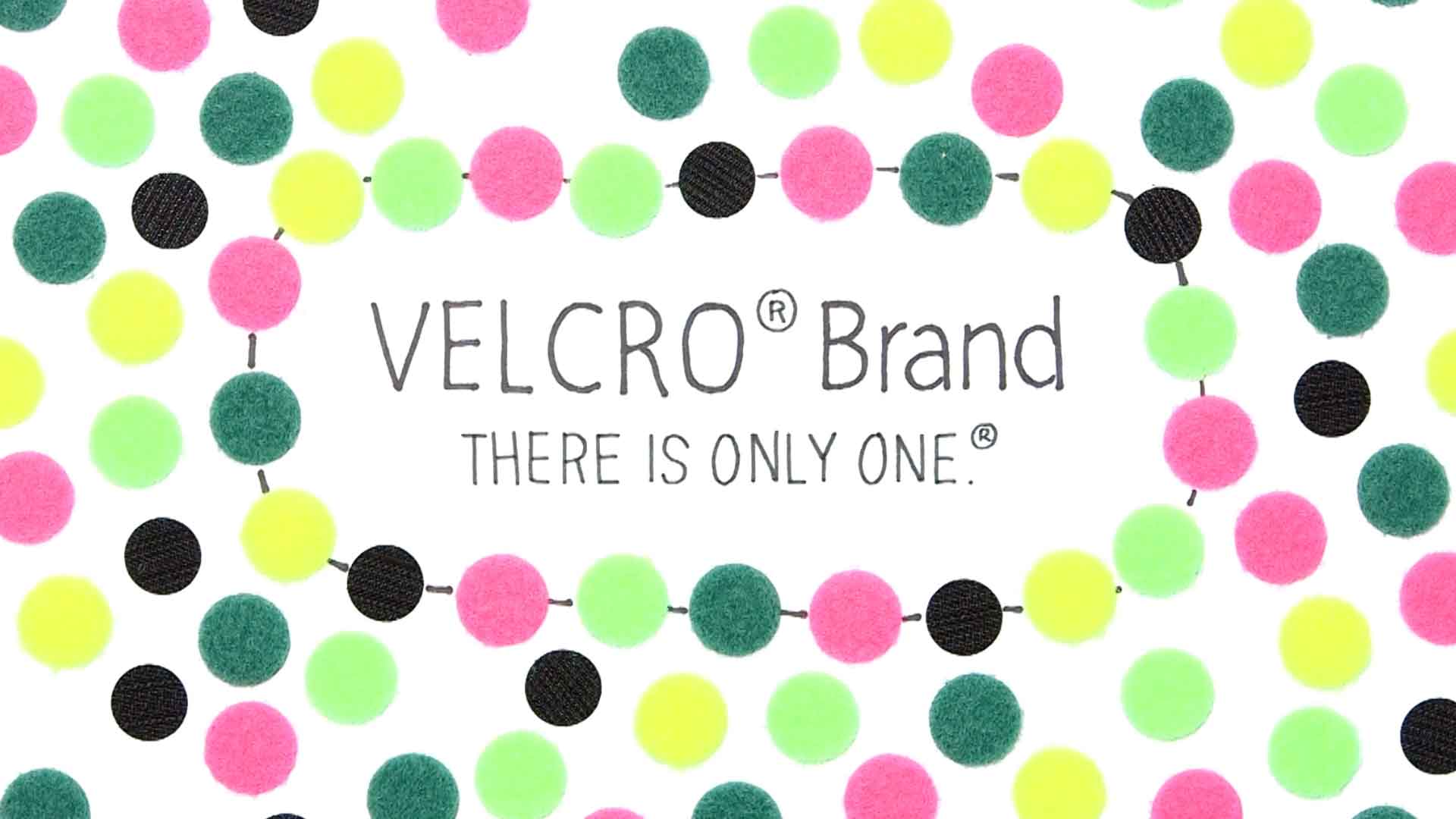 A page full of coloured VELCRO® brand hook and loop sticky dots. In the centre reads: VELCRO® Brand. There is only one.