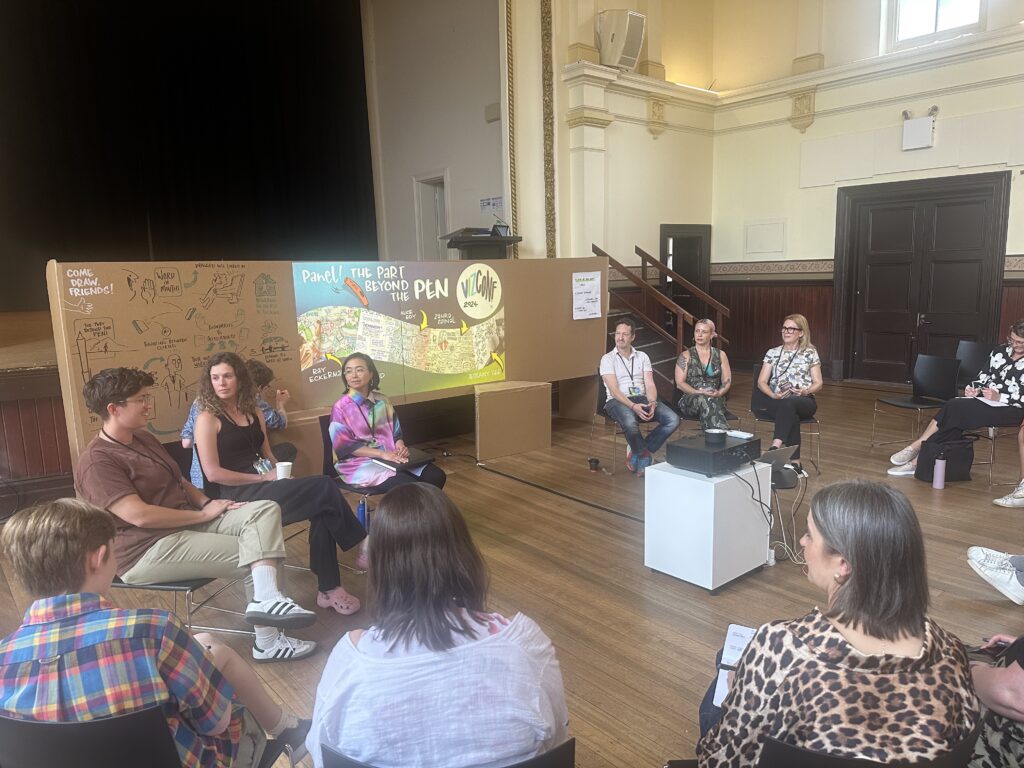 The panel discussion at VizConf 2024. The panel comprised, from left to right, Emma Rowland, Alice Edy, Zahra Zainal, Ray Eckermann, Jessamy Gee, and hosted by Debbie Wood.