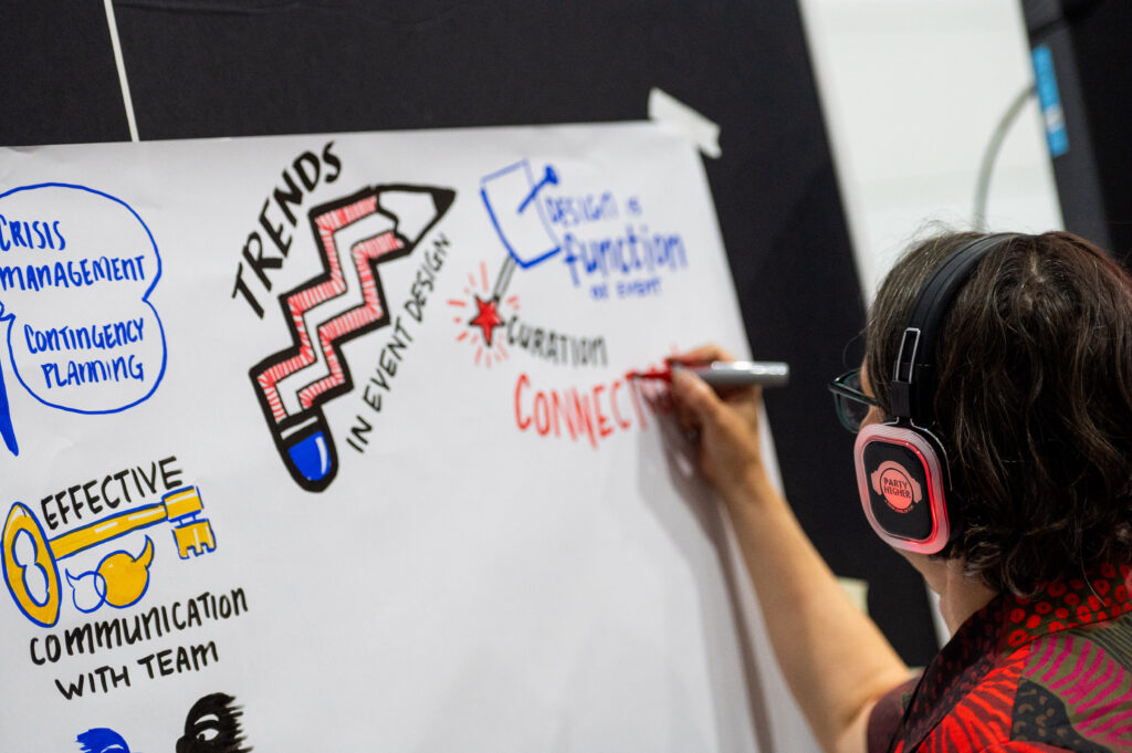 Image of graphic recorder wearing headphones at an event 